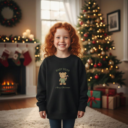 Mädchen mit rotem Haar trägt das schwarze Weihnachts Sweatshirt - Bärenfamilie mit 'Baby Bear'-Design. Nachhaltige und gemütliche Kinderbekleidung zu Weihnachten.