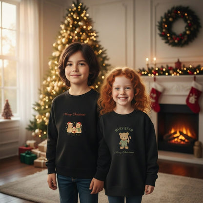 Zwei Kinder tragen das schwarze Weihnachts Sweatshirt - Bärenfamilie vor einem festlich geschmückten Weihnachtsbaum. Perfekt für festliche Familienfotos.