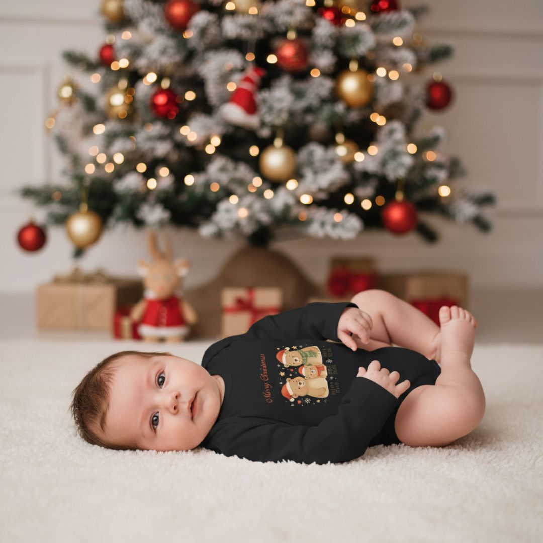 Baby liegt auf Teppich in schwarzem Weihnachtsstrampler mit Bärenfamilie. Weicher Langarm-Babystrampler aus Baumwolle für festliche Anlässe.