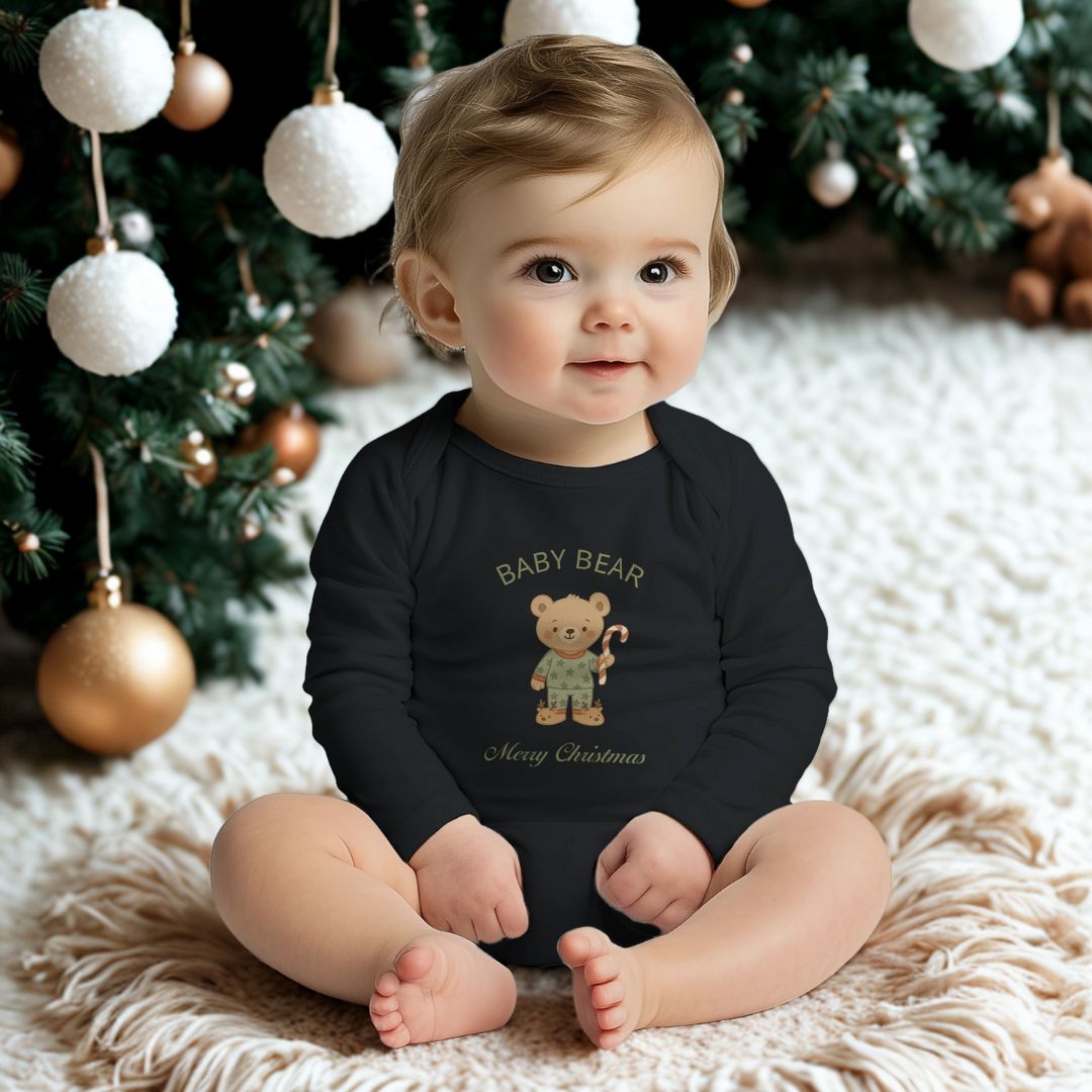 Baby in schwarzem Weihnachtsstrampler mit Babybär-Motiv sitzt vor Tannenbaum. Langarm, 100% Baumwolle, festliche Babybekleidung.