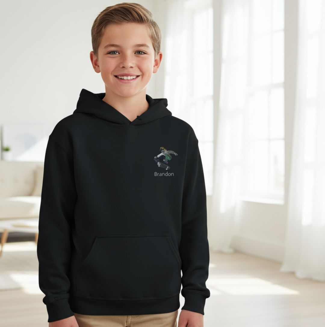 Personalisierte Kinder Hoodie Skateboarder mit Namen bestickt in Schwarz, getragen von Junge in modernem Wohnzimmer. Ideal für kleine Skater.