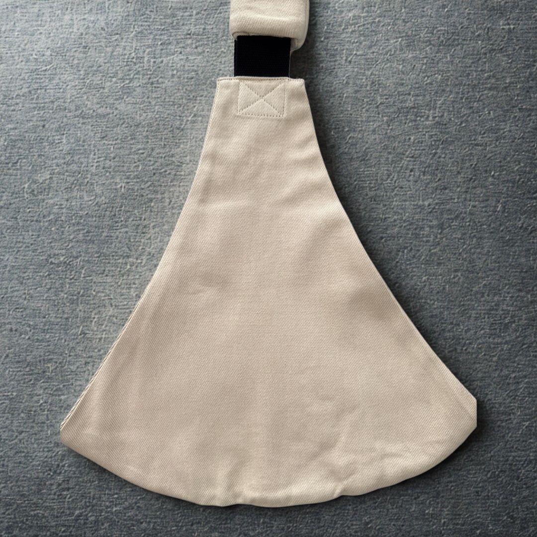 Rückansicht der beigen Hüfttrage – verstellbare Babytrage ab 9 Monate mit breiter Sitzfläche für ergonomisches Tragen.